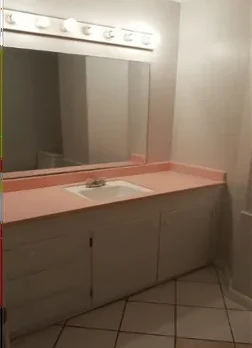 Old bathroom vanity with pink laminate counter before remodel