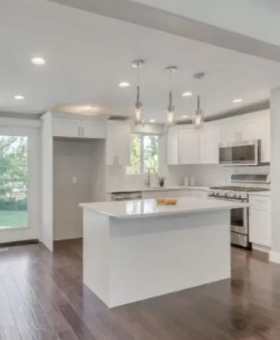 Remodeled white kitchen with island and pendant lighting